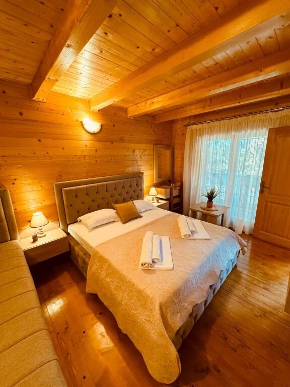 Wood-panelled bedroom with double bed and balcony door