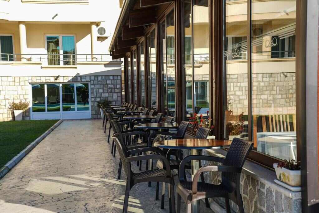 Shaded restaurant terrace with tables and chairs