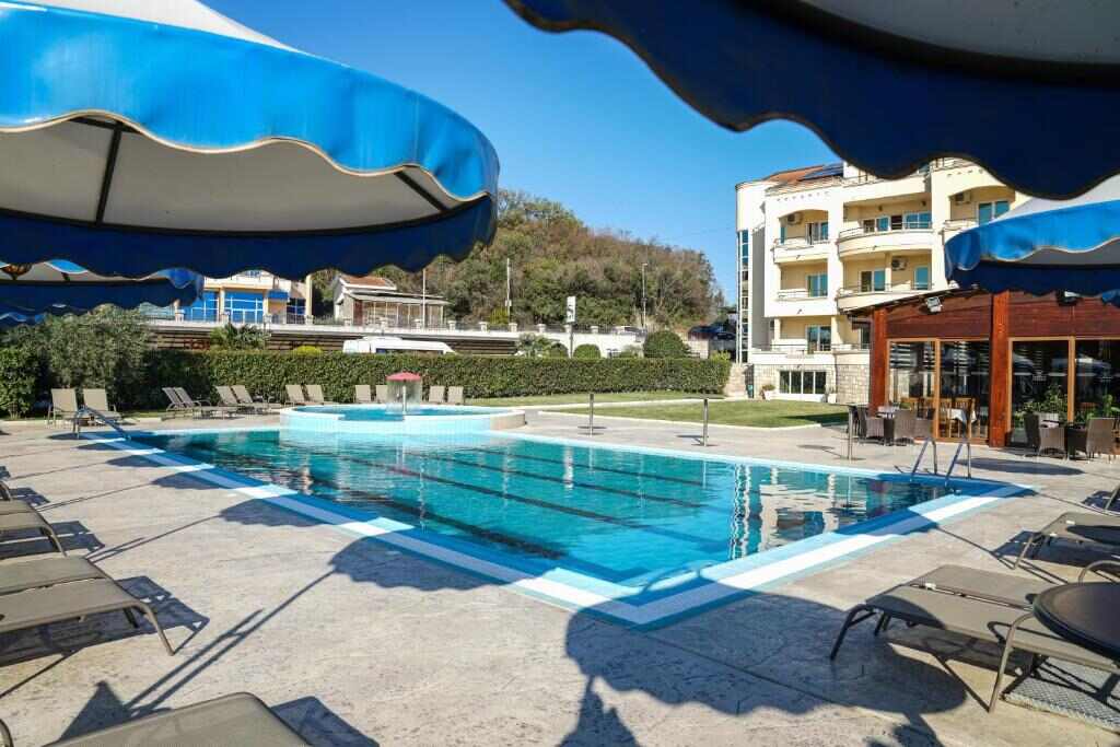 Outdoor swimming pool with sun loungers and parasols